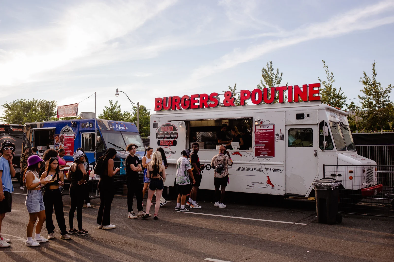 Customers lined up ordering food at outdoor food trucks outside The Bench sports bar in Fort Worth